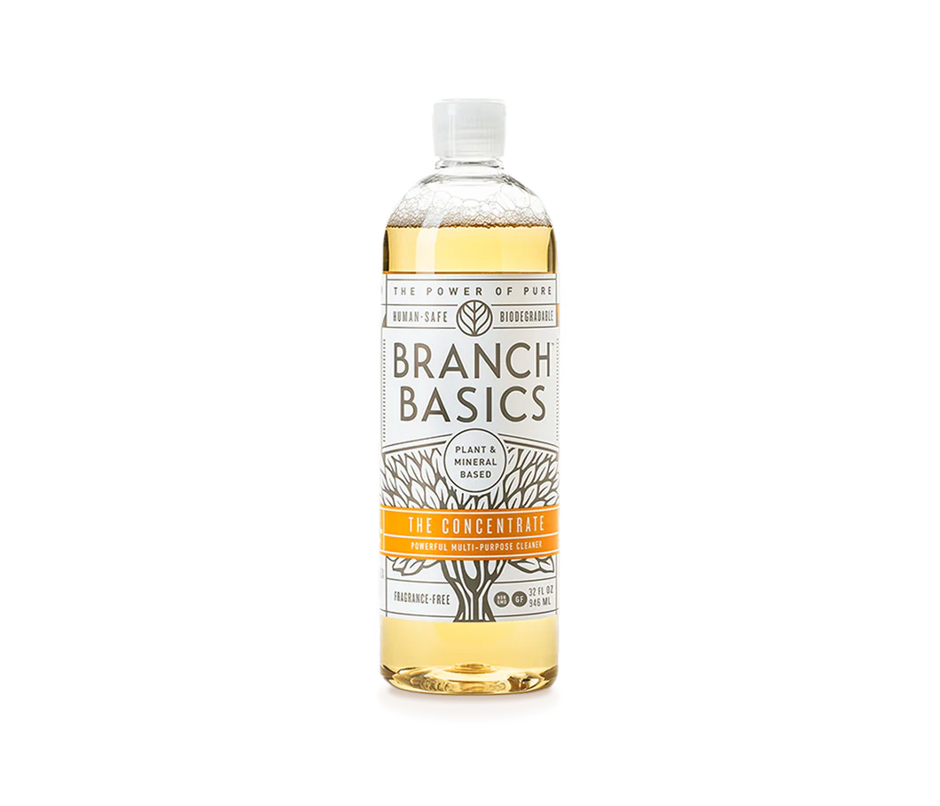 bottle filled with yellow water and branch basics logo sticker on a clear background